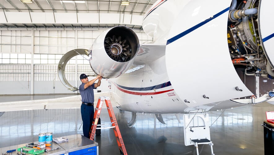 A Clay Lacy mechanic works on a Dassault Falcon 